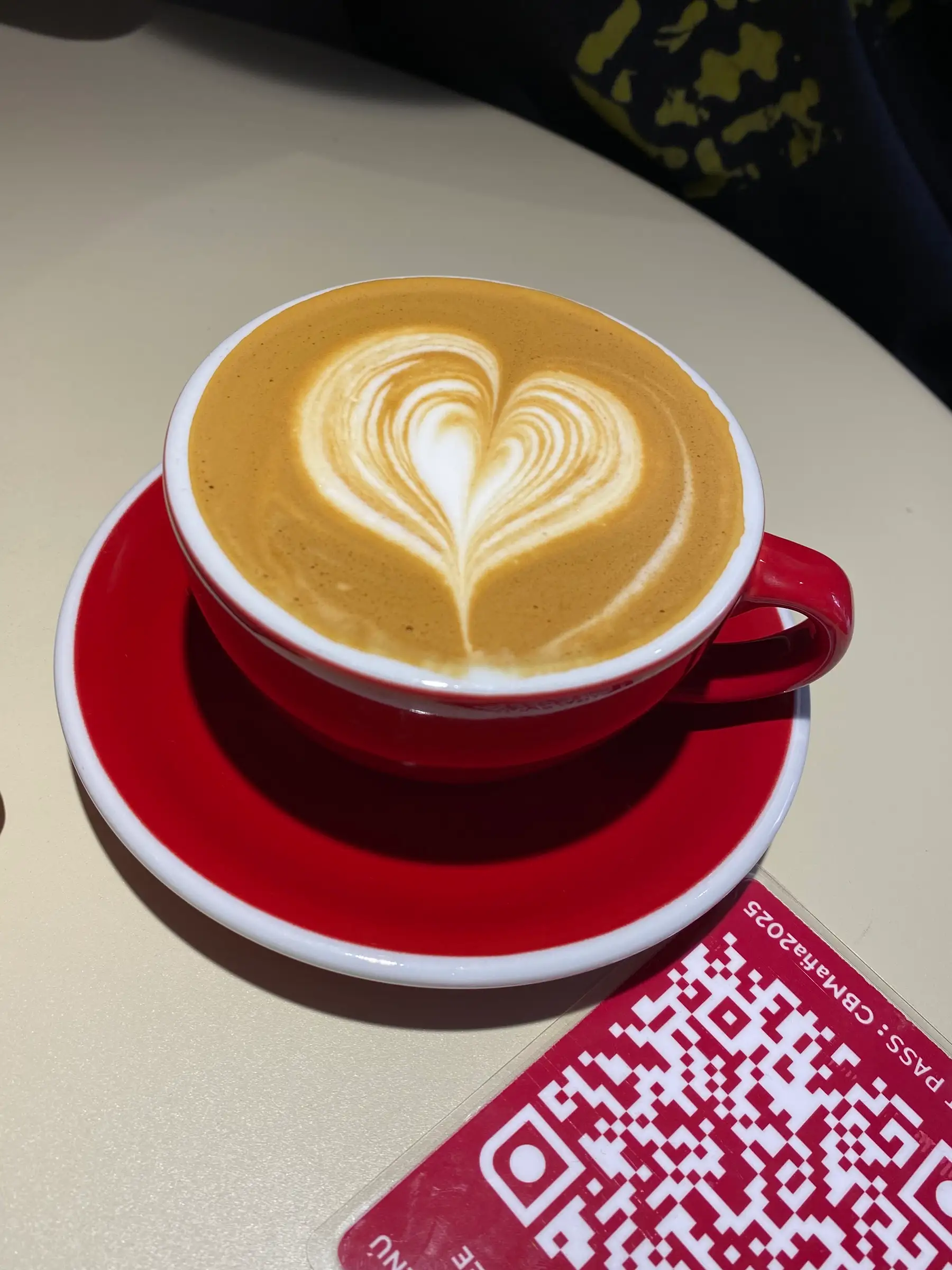 Flat white con corazón en una taza roja